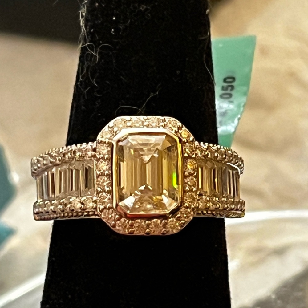 Gorgeous emerald cut moissanite with baguette down each shank in sterling silver